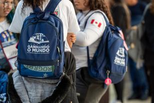 Foto com alunos segurando mochilas